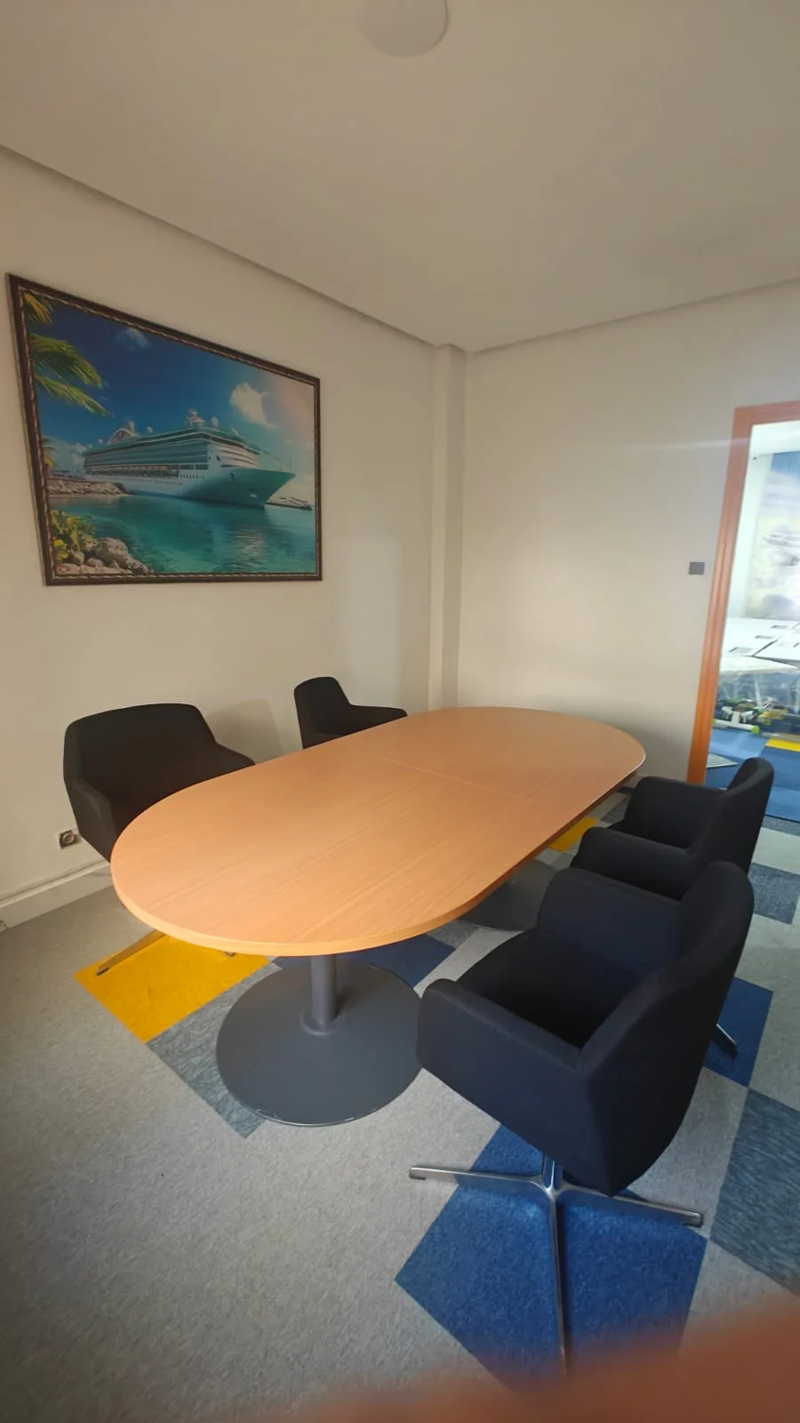 The Travel Hub meeting room with an oval table and six chairs